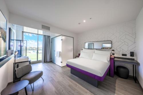 FounexYOTEL Geneva Lake的酒店客房带一张床铺、一张书桌和一间卧室