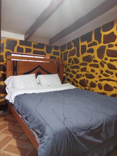 奥兰太坦波Sacred Point的一张位于带墙壁的房间里的床