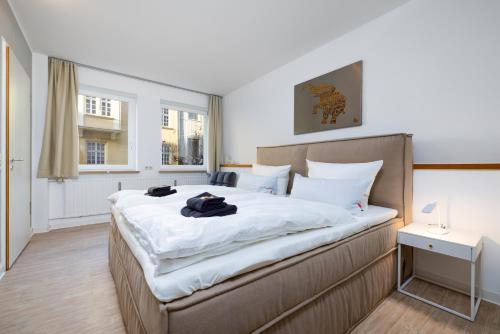 奥格斯堡Primero City-Loftdomizil Innenstadt 84qm Netflix的一间卧室配有一张带白色床单的大床