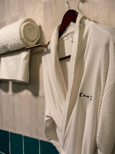 圣路易斯波托西Casa H Hotel Boutique的浴室的衣架上挂着白色的长袍