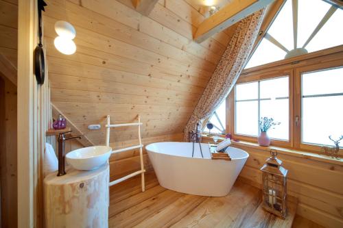 斯扎法拉瑞Marusina Chalets的木墙内带大浴缸的浴室