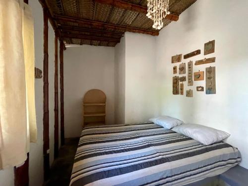 曼克拉Naif habitaciones的一间卧室配有带条纹毯子的床