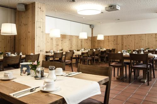 费尔德基希洛文客栈酒店的餐厅拥有木墙和桌椅