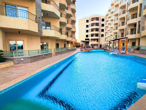 伊斯梅利亚Beach Front Apartment in Hurghada La Quinta Beach Compound的一座大型游泳池,位于部分公寓大楼前