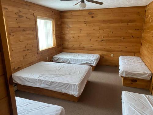 BrimleyBrimley Lodge / Sleeps 36 / Snowmobile & ORV Trail的带木墙的客房内的三张床