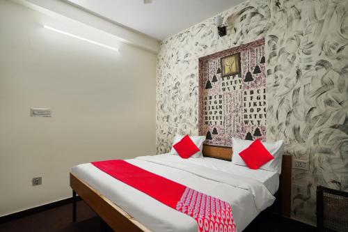 斋浦尔Flagship Hotel Big Vine的一间卧室配有一张带红色枕头的床