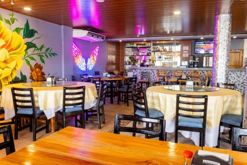 佩诺诺梅Hotel Guacamaya的一间带桌椅的餐厅和一间酒吧