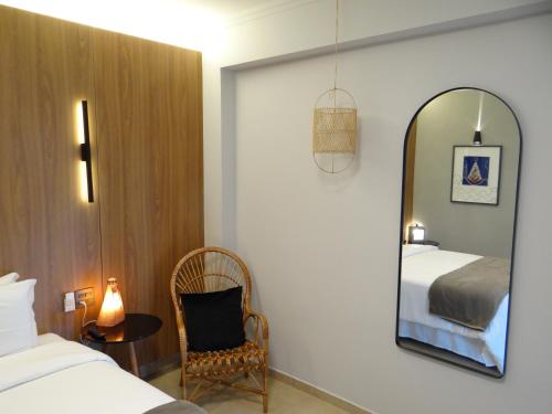 阿帕雷西达Hotel Porto Real Aparecida的一间卧室配有镜子、一张床和一把椅子