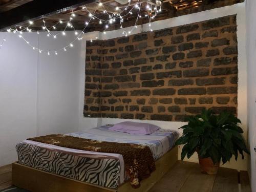 穆库热Hostel Solar的砖墙和灯的房间里一张床位