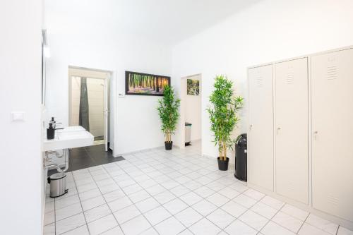 维也纳Robin Wood Apartment的一间带水槽的浴室和白色瓷砖地板。