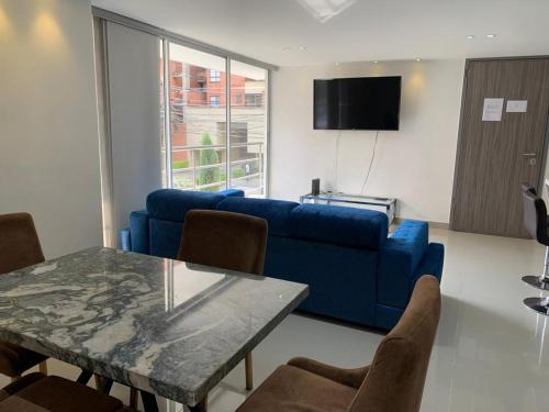麦德林Medellín, conquistadores 201的客厅配有蓝色的沙发和桌子