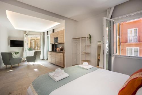 马拉加Diana Suites 23的一间卧室配有一张大床和两条毛巾