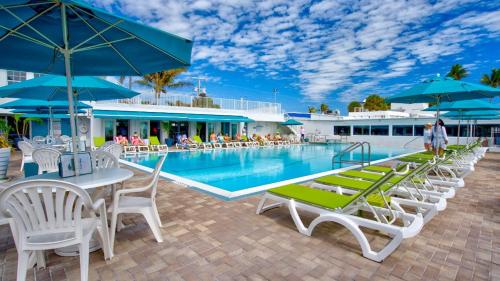 基克罗尼海滩Waterfront House with 37ft Dock & Cabana Club的一个带桌椅和遮阳伞的游泳池