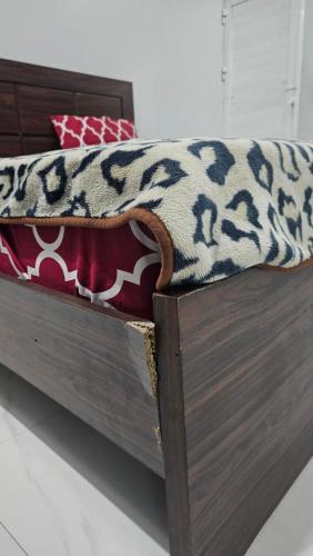 卡拉奇Luxury Hotel Rooms的一张木床,上面有毯子