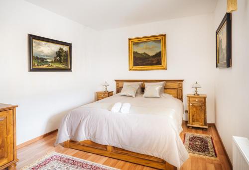 俄斯特拉发Château Rychvald的一间卧室配有一张带2个床头柜和2幅画作的床
