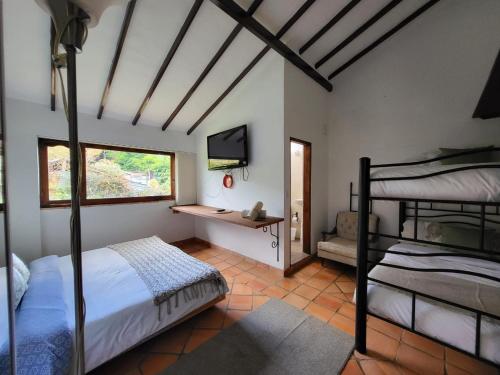 莱瓦镇Hotel Ficus Villa de Leyva的一间卧室配有两张双层床和一张书桌