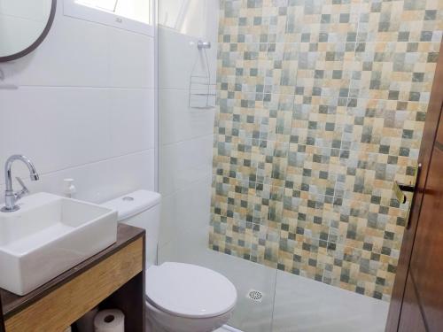 伊塔尼亚恩Recanto Solarium的浴室配有卫生间、盥洗盆和淋浴。