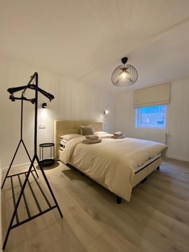 布兰肯贝赫Les amies的一间卧室配有一张大床和一个三角架