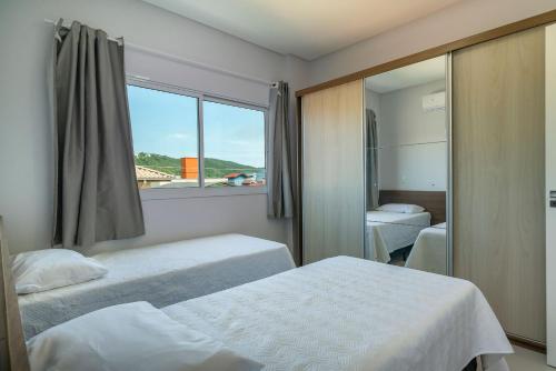 邦巴斯Aluguel Apartamento 2 Suítes em Bombas的酒店客房设有两张床和窗户。