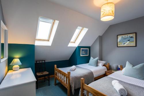 布鲁莱迪Shorefield, Bruichladdich的一间卧室设有两张床和两个窗户。