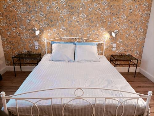 摩泽尔河畔圣莫里斯Domaine de la Moselle的一间卧室配有一张带花卉壁纸的床