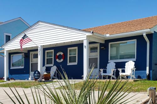 大西洋滩Toes In The Sand的蓝色的房子,配有白色椅子和美洲国旗