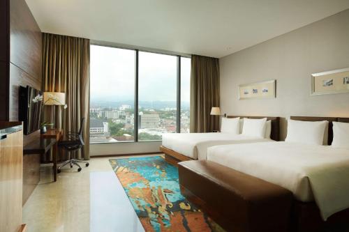 万隆希尔顿万隆酒店的酒店客房设有两张床和大窗户。
