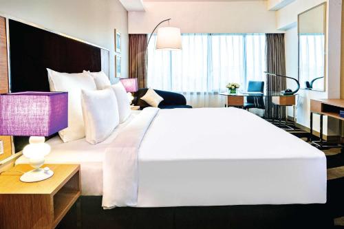 吉隆坡吉隆坡孟沙温德姆至尊酒店的一张大白色的床,位于酒店客房内
