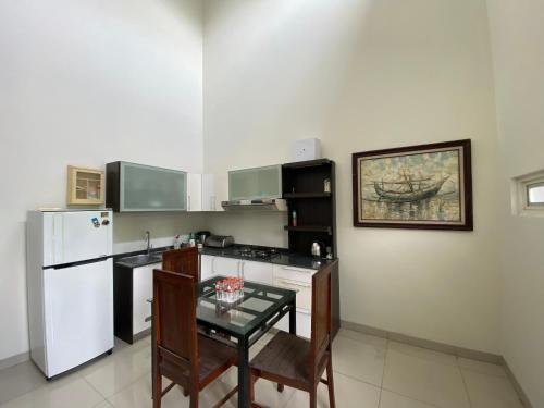 泗水The 8 House – Surabaya City Center的厨房配有桌子和白色冰箱。