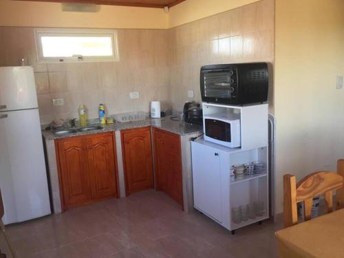 多拉达斯海滩Casa Las Dunas Doradas的厨房配有白色冰箱和微波炉