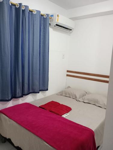 圣若泽-迪里巴马尔Apartamento 1 km da praia do aracagir confortavel的一间卧室配有一张蓝色和紫色窗帘的床