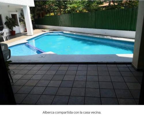 曼萨尼约Gran casa con alberca en playa的庭院内的游泳池,铺有瓷砖地板