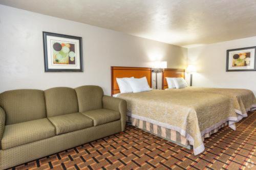 里兹波特Anchor Bay Inn By OYO Reedsport的酒店客房,配有床和沙发