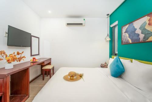 岘港May Beach Hotel的客房设有1张床、1张办公桌和1台电视。