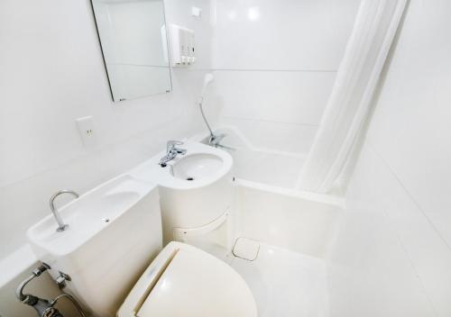 福冈TKP Sunlife Hotel的白色的浴室设有卫生间和水槽。