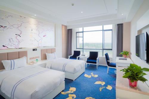 华阴华山欣源国际酒店的一间酒店客房,设有两张床和电视