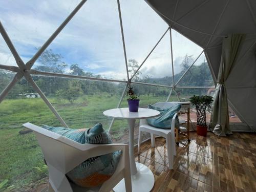 曼努埃尔安东尼奥La Comarca River Glamping Dome near Manuel Antonio的美景帐篷,配有桌椅