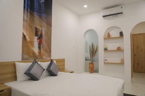 永隆Somo Farm Cửu Long的卧室配有一张白色床,墙上挂有绘画作品