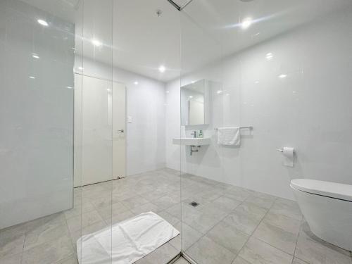 悉尼Burwood Cozy Apartment Free Parking的带淋浴、卫生间和盥洗盆的浴室