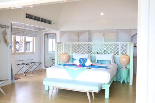 班柯木穆岛西拉威海滩度假酒店的一间卧室配有一张白色的床和蓝色床头板