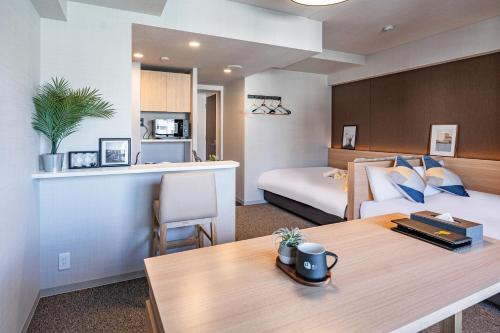 大阪Apartment Hotel 11 Shinsaibashi III的一间酒店客房,在客房内配有一张床铺和一张桌子