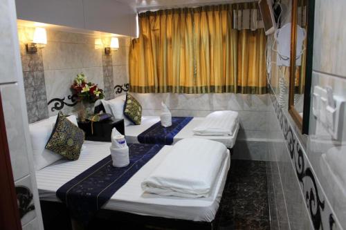 香港SHANGRI-LA GUEST HOUSE的一间设有三张床的客房,备有毛巾