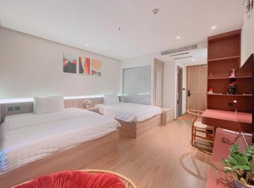 绥和市APEC MANDALA CONDOTEL PHÚ YÊn的一间卧室配有两张床和钢琴