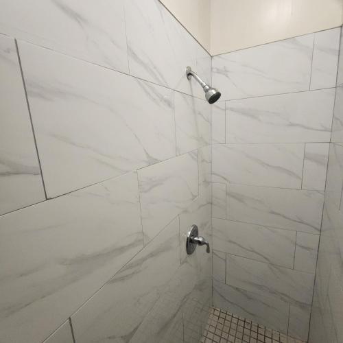 纽约New York City Guest House 2的浴室设有白色大理石瓷砖和淋浴。
