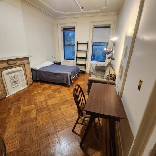 纽约New York City Guest House 2的卧室配有1张床、1张桌子和1把椅子