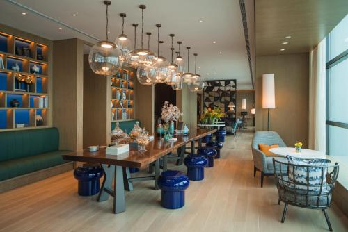 上海上海西岸美高梅酒店的一间带长桌和椅子的用餐室