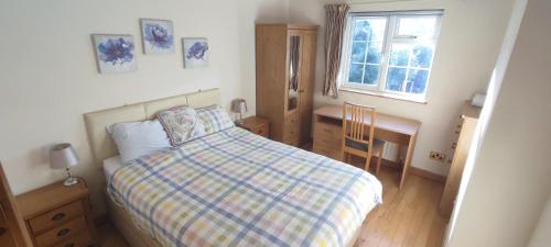 剑桥希尔附楼公寓的一间卧室配有一张床、一张书桌和一个窗户。