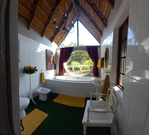 彼得马里茨堡阿斯科特丛林住宿加早餐旅馆的带浴缸、卫生间和窗户的浴室
