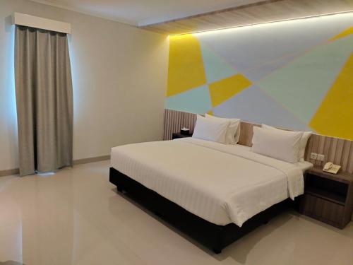 KamparganyaKey Inn Hotel Bogor的卧室配有一张色彩缤纷的壁画床。