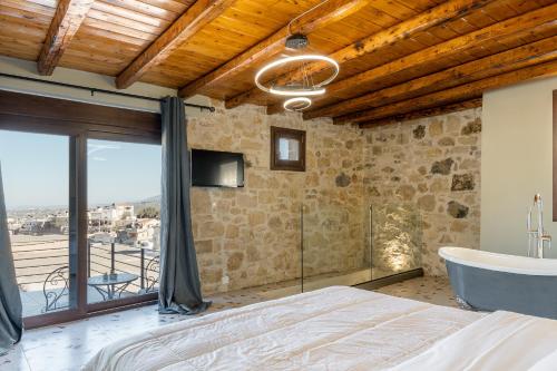KrousónAthali villa的一间卧室配有一张床、一个浴缸和一台电视。